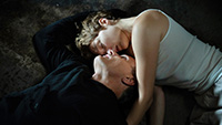 image of woman and man laying on floor, embracing