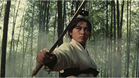 image of woman holding martial arts weapon in bamboo forest